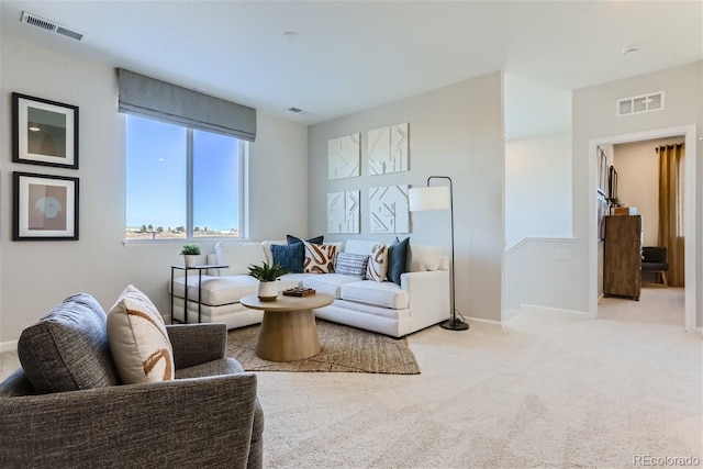 living area featuring visible vents, baseboards, and carpet flooring