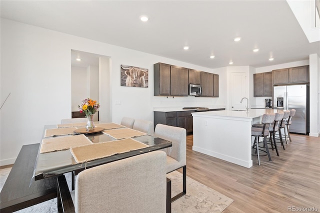 dining space with recessed lighting, baseboards, and light wood-style flooring