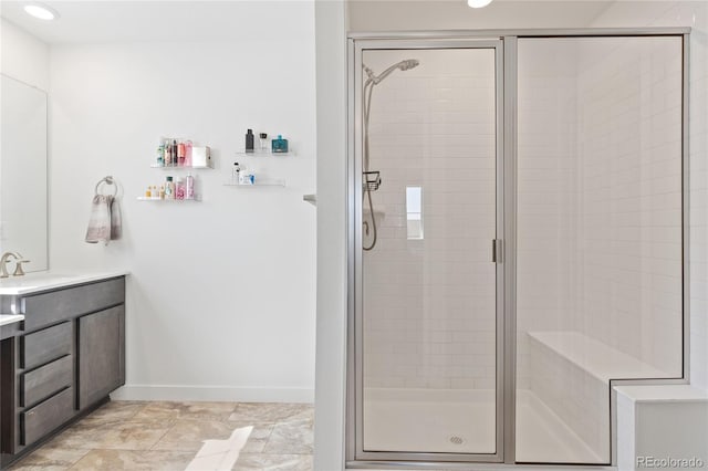 full bathroom featuring baseboards, vanity, and a shower stall