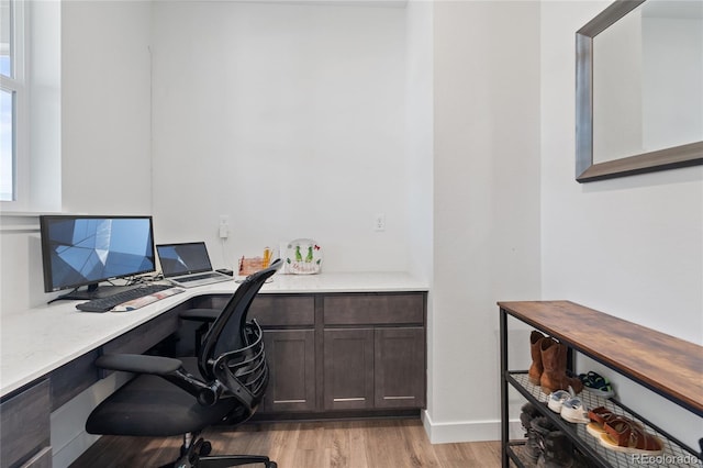 office area with built in study area and light wood finished floors