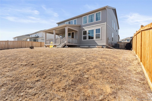 back of property with a deck, a fenced backyard, and central AC