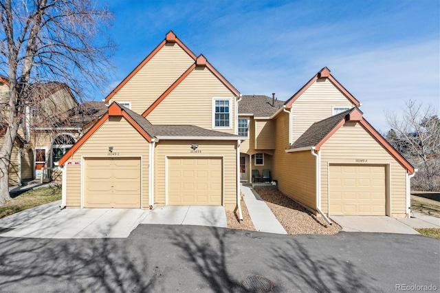 view of front facade with a garage and a shingled roof