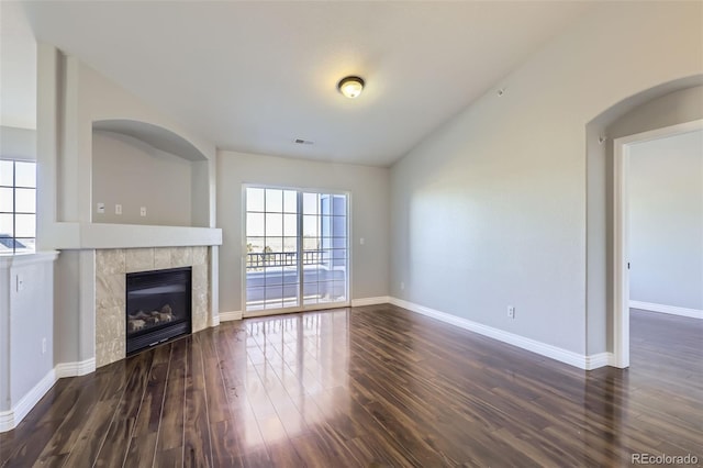 unfurnished living room with dark wood-type flooring and a fireplace