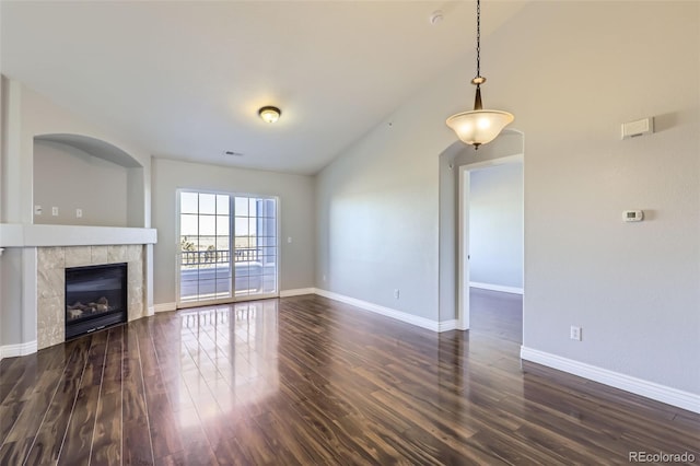 unfurnished living room with a fireplace, lofted ceiling, and dark hardwood / wood-style flooring