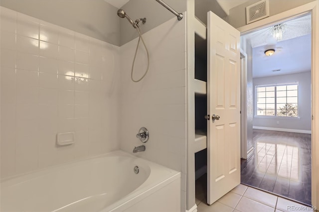 bathroom featuring tile patterned flooring and washtub / shower combination