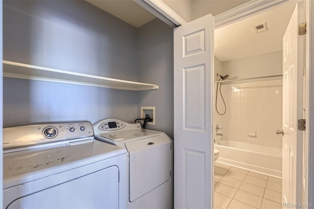 laundry room featuring separate washer and dryer and light tile patterned floors