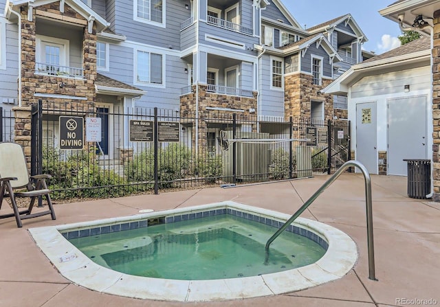 view of swimming pool featuring a hot tub