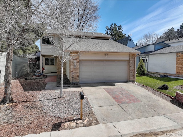 traditional home with concrete driveway, an attached garage, fence, and brick siding