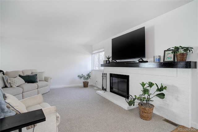 living room with a brick fireplace, carpet, visible vents, and baseboards