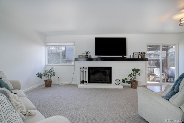 living area featuring a brick fireplace, carpet, and baseboards