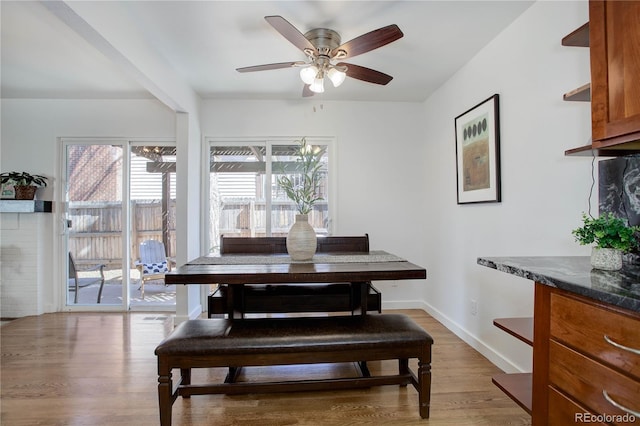 dining area featuring light wood-style floors, baseboards, and ceiling fan