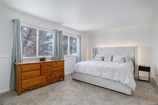 bedroom featuring baseboards and light carpet