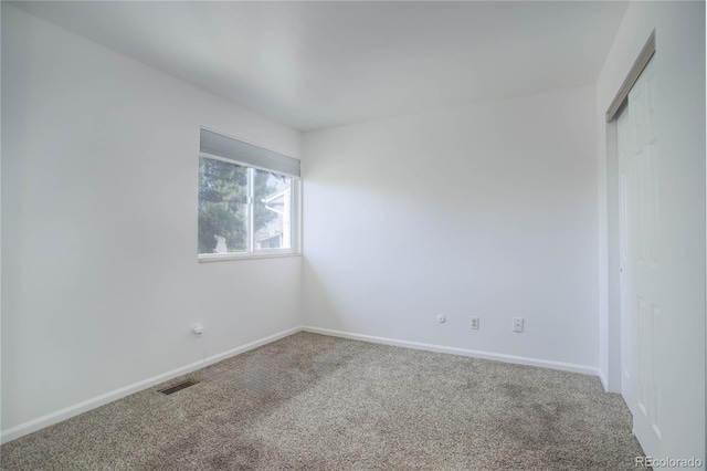 unfurnished room with carpet flooring, baseboards, and visible vents