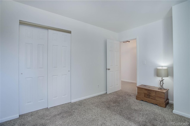 unfurnished bedroom with a closet, baseboards, and carpet floors