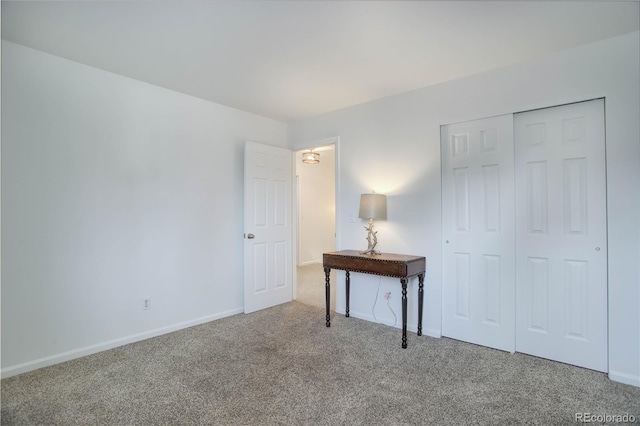 unfurnished bedroom with a closet, baseboards, and carpet