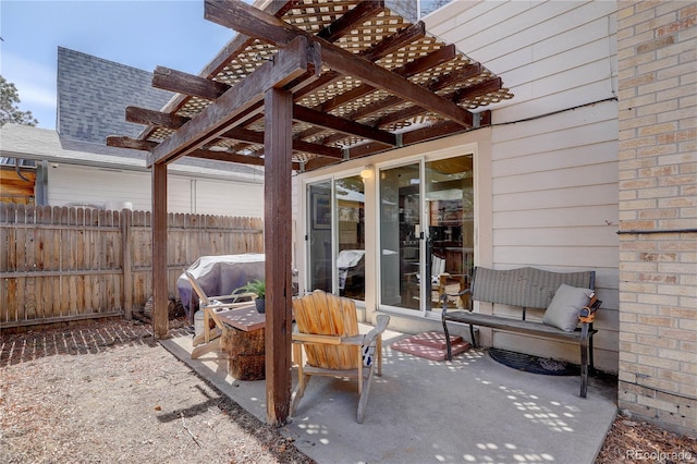 view of patio with area for grilling, a pergola, and fence