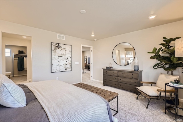 carpeted bedroom with a spacious closet and a closet