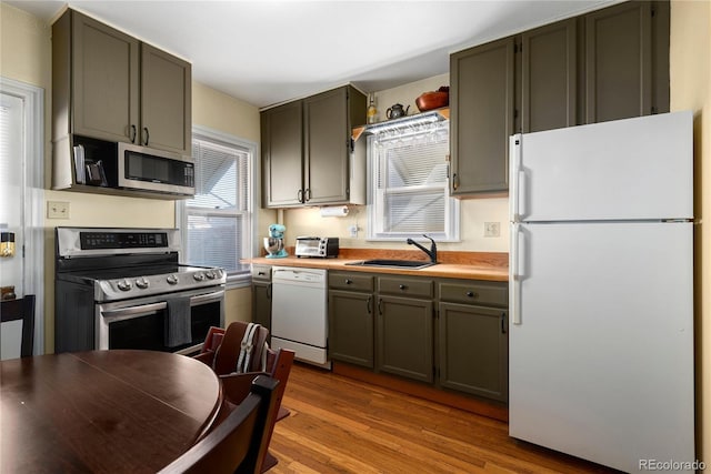 2886 S Acoma St, Englewood, CO 80110 - kitchen featuring a sink, light countertops, stainless steel appliances, wood finished floors, and a toaster
