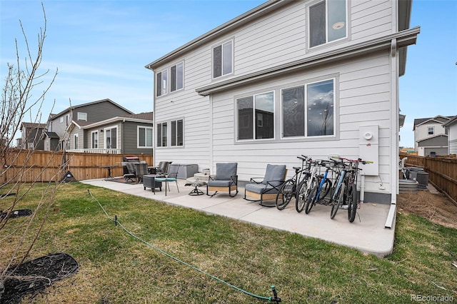rear view of property with a fenced backyard, central AC unit, an outdoor living space, a patio, and a yard