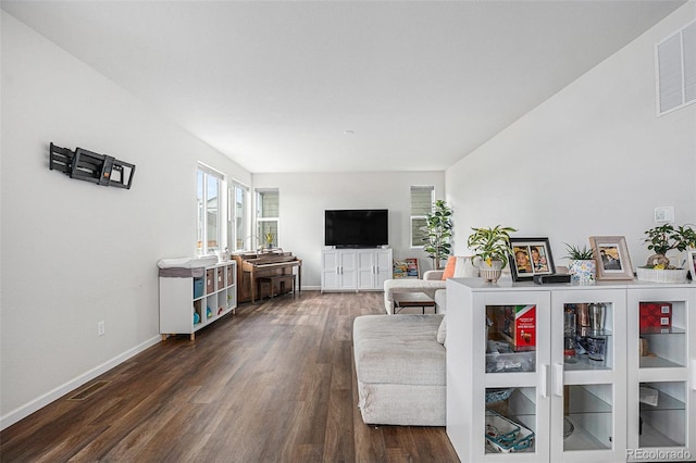 living area with visible vents, baseboards, and dark wood-style floors