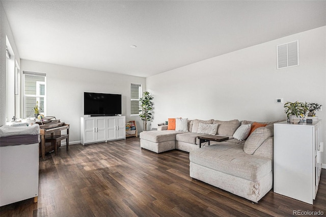 living room featuring visible vents and dark wood finished floors