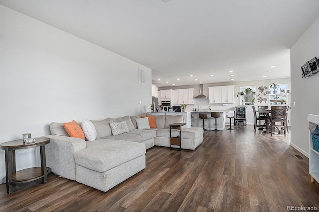 living room featuring recessed lighting, dark wood finished floors, and visible vents