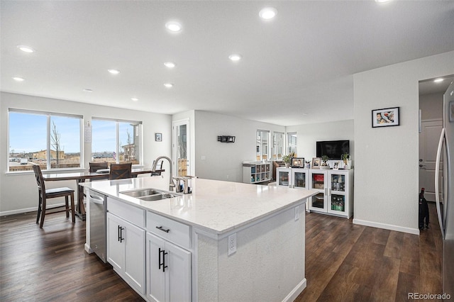 kitchen featuring stainless steel dishwasher, a sink, dark wood-style flooring, and baseboards