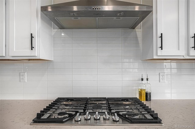 kitchen with white cabinetry, stainless steel gas cooktop, under cabinet range hood, and tasteful backsplash