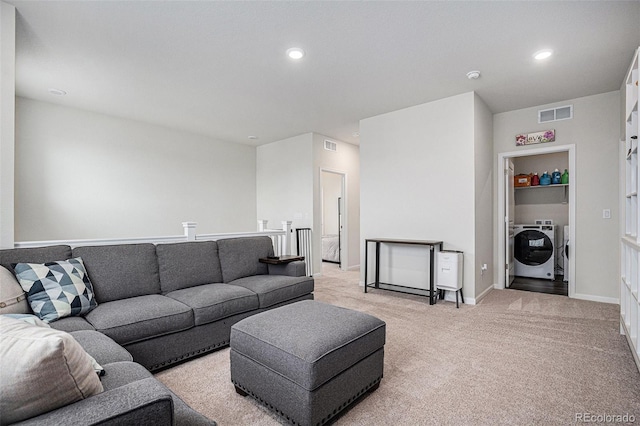 living room with washer and dryer, recessed lighting, visible vents, and light carpet