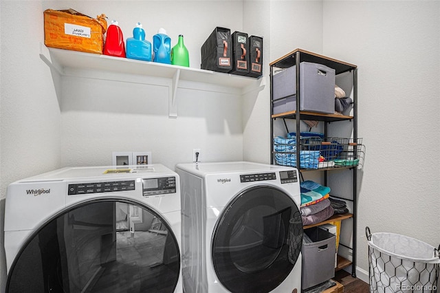 washroom featuring separate washer and dryer, laundry area, baseboards, and wood finished floors