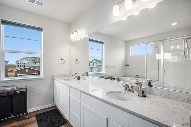 full bath with visible vents, wood finished floors, baseboards, a sink, and a stall shower
