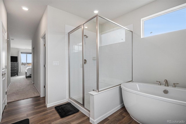 ensuite bathroom featuring connected bathroom, baseboards, a shower stall, and wood finished floors