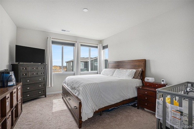 bedroom with visible vents and light colored carpet