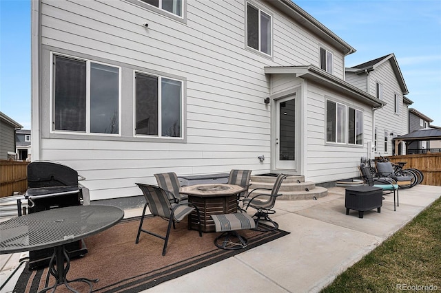 back of house with entry steps, fence, an outdoor fire pit, and a patio area