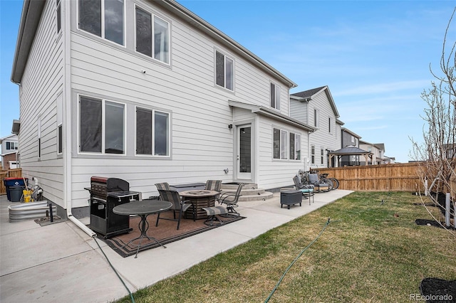 back of property featuring fence, a patio, entry steps, and a lawn