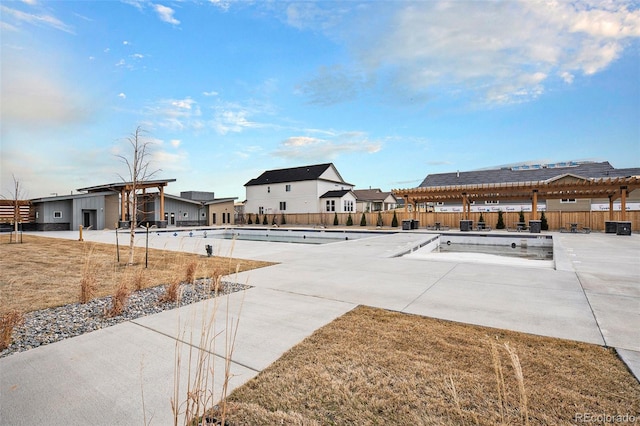 exterior space with a community pool, fence, and a residential view
