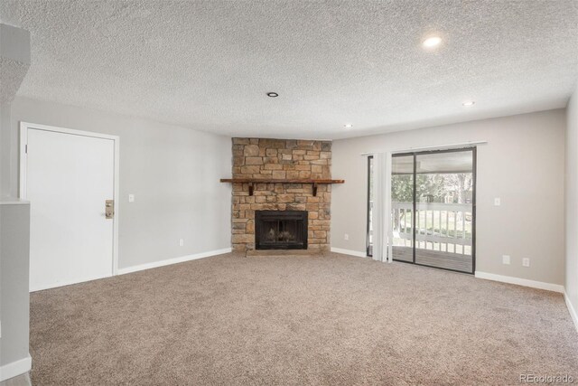 18071 E Kentucky Ave Unit 203, Aurora, CO 80017 - unfurnished living room featuring carpet flooring, a stone fireplace, a textured ceiling, recessed lighting, and baseboards