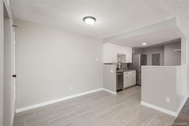 18071 E Kentucky Ave Unit 203, Aurora, CO 80017 - kitchen with stainless steel appliances, a textured ceiling, baseboards, and white cabinets