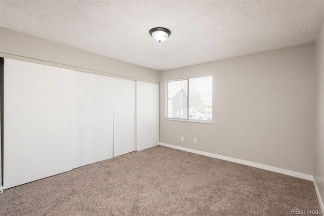 18071 E Kentucky Ave Unit 203, Aurora, CO 80017 - unfurnished bedroom with carpet, a closet, and a textured ceiling