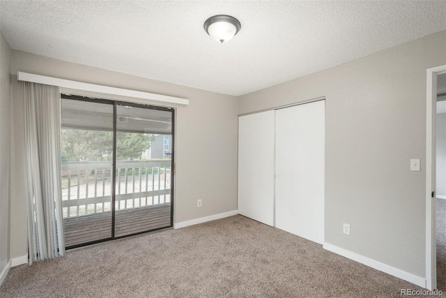 18071 E Kentucky Ave Unit 203, Aurora, CO 80017 - unfurnished bedroom with access to exterior, carpet, a textured ceiling, a closet, and baseboards