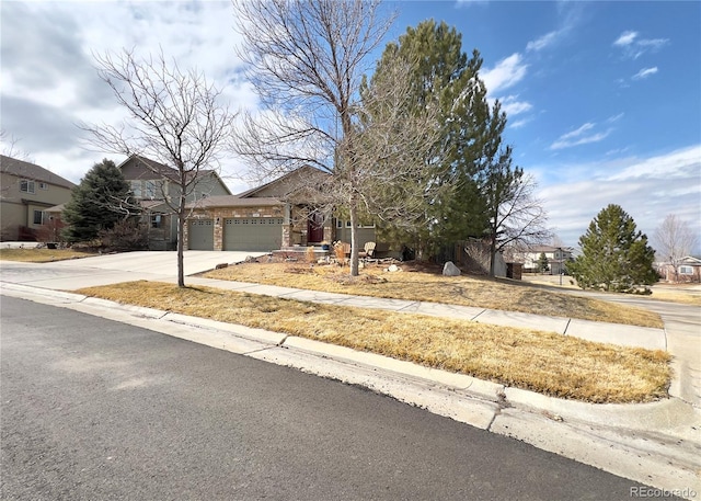 view of property hidden behind natural elements with concrete driveway and an attached garage