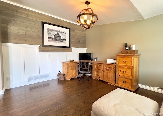 office featuring visible vents, a wainscoted wall, dark wood-style flooring, a decorative wall, and a notable chandelier