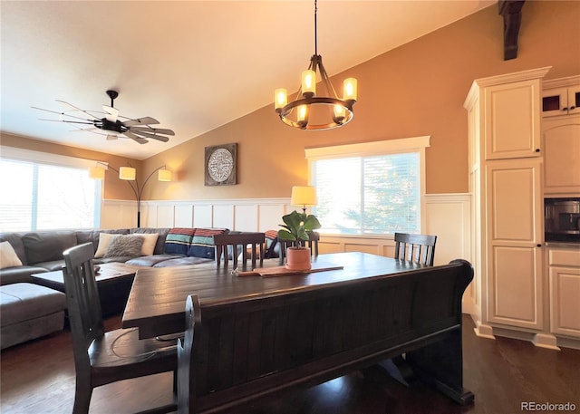 dining room featuring dark wood-style floors, plenty of natural light, wainscoting, and vaulted ceiling