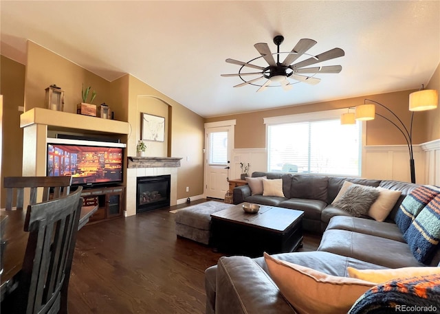 living room with lofted ceiling, a tile fireplace, wainscoting, and wood finished floors