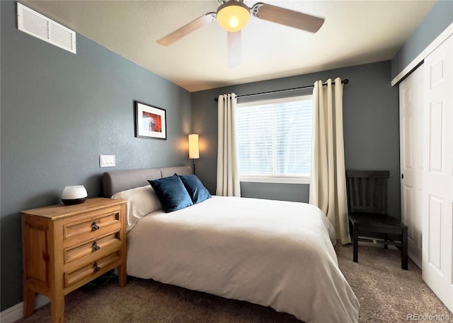 carpeted bedroom featuring a closet, visible vents, and ceiling fan