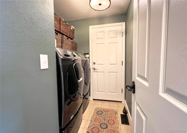 washroom featuring light tile patterned floors, laundry area, and separate washer and dryer