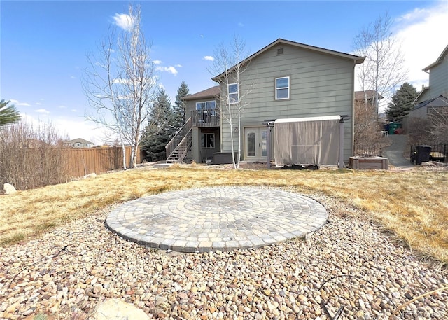 rear view of property featuring a deck, french doors, fence, and stairway