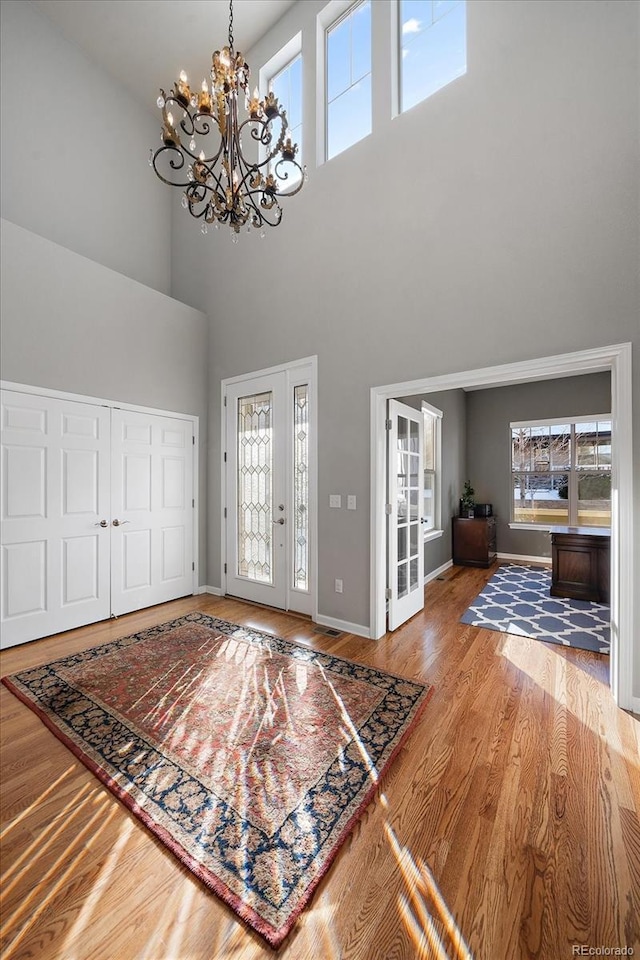 foyer entrance with hardwood / wood-style flooring and an inviting chandelier