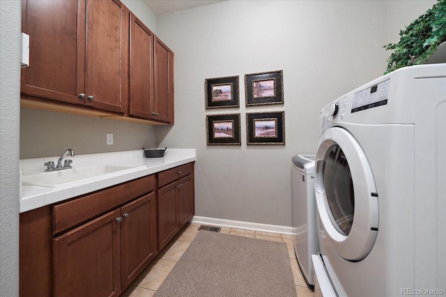 washroom with washer and dryer, sink, light tile patterned floors, and cabinets