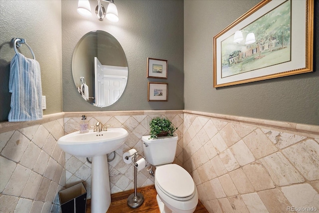 bathroom with tile walls and toilet